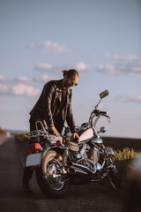 Fototapeta na wymiar handsome male biker with classical motorcycle on road