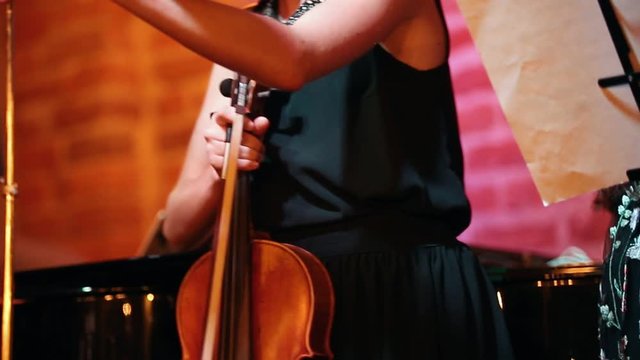 Girl with a stringed instrument is preparing for the performance