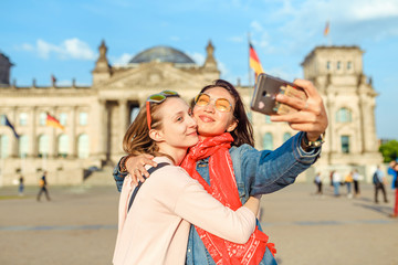 Naklejka premium Dwa szczęśliwa kobieta robi selfie na tle Reichstag Bundestag budynek w Berlin. Koncepcja podróży i miłości w Europie