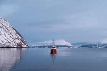 Winter landscape of the fishing boat in the Norwegian fjord.