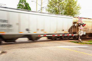Goods Train in Motion at a Railway Crossing on a Summer Day
