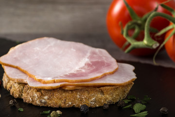Open sandwich with pork smoked ham on a dark slate