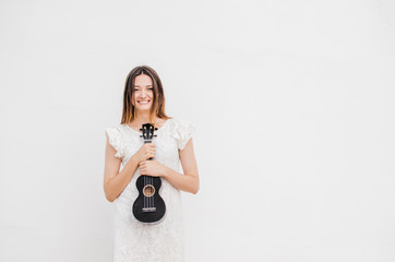 Young beautiful woman having fun with ukulele