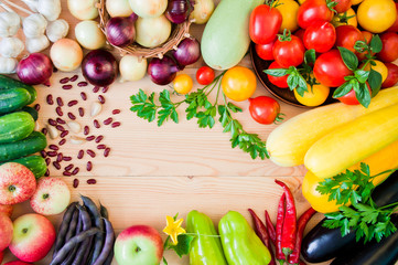 Frame of fresh vegetables and fruits on a white wooden table