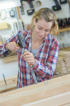 Female Cabinet Maker Making Tiny Details On The Wood