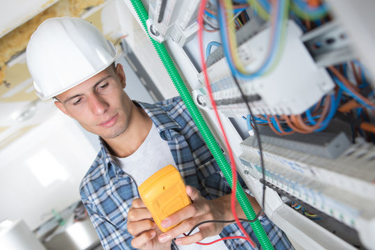 young electrician using a multimeter