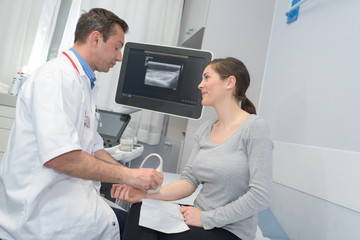 doctor with female patient undergoing arm echography