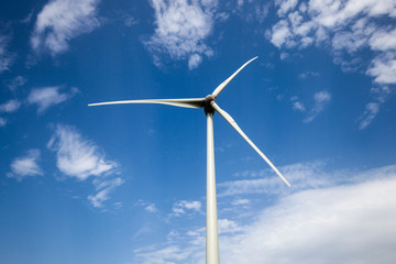 Wind turbine main rotor over blue cloudy sky