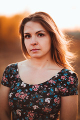 portrait of a beautiful girl in a field on a sunset background