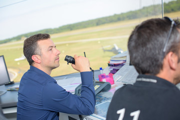 Control tower worker talking into receiver
