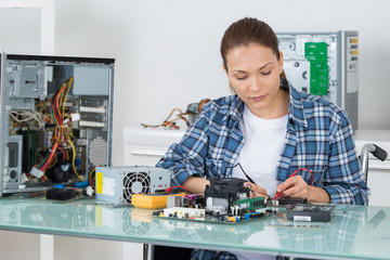 tech tests electronic equipment in service centre