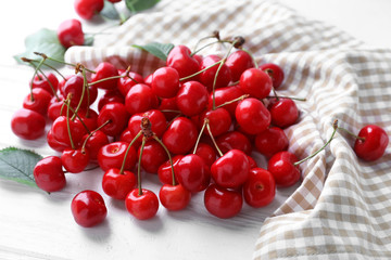 Tasty ripe cherries on white wooden background