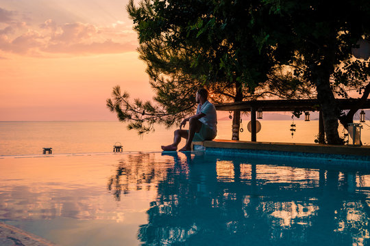 man watching sunset swimpool sunset ocean Fethiye Turkey