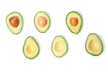 Halves of ripe avocados on white background, flat lay