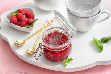Composition with sweet homemade raspberry jam on color table