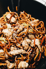 Meat with noodles in black plate, Asian cuisine, chopsticks