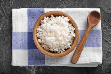 Bowl with boiled white rice on grey textured background