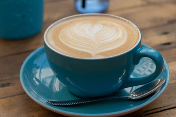 latte coffe in blue mug on wooden table