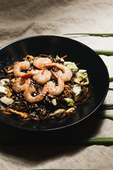 Delicious meal with shrimps in black plate, traditional Aisan food