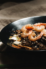 Delicious meal with shrimps in black plate, traditional Aisan food