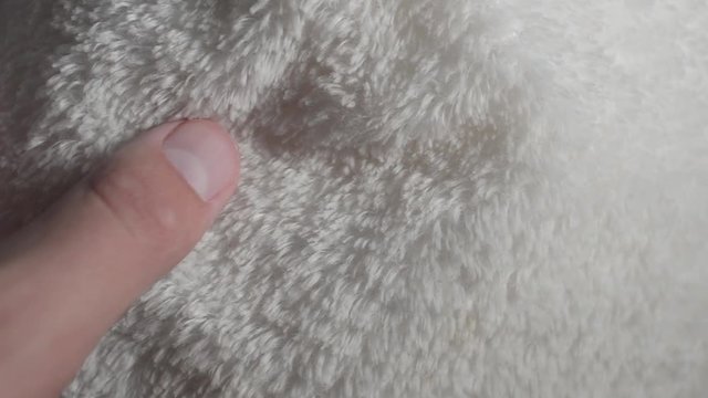 Closeup of a hand taking syntheticpolyester fur.