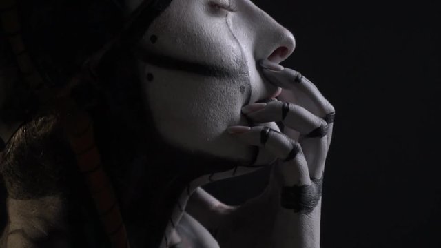 Shooting close-up, a woman cyborg touches herself with her hands, self-awareness