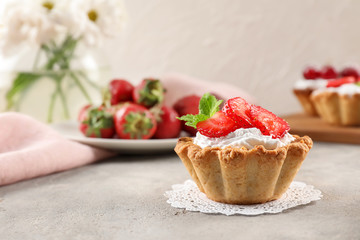 Tasty tartlet with strawberry on table
