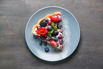 Plate with piece of delicious berry pie on table