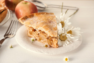 Plate with piece of tasty apple pie on table