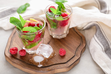 Glasses of fresh raspberry mojito on wooden board