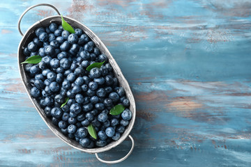Basket with ripe blueberries on wooden table