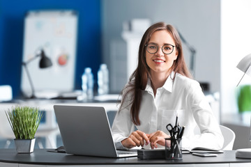 Young businesswoman working in office - obrazy, fototapety, plakaty