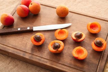 Board with fresh apricots on wooden table
