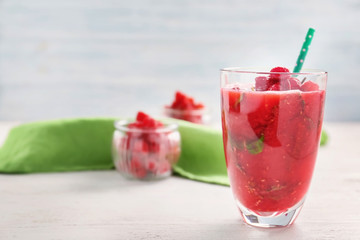 Glass of tasty raspberry smoothie on table