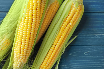 Fresh corn cobs on wooden background