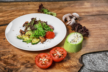 Plate with delicious vegetable salad on wooden table
