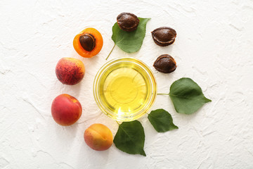 Composition with apricot essential oil on white textured background