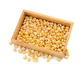 Wooden crate with ripe corn kernels on white background
