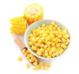 Scoop and bowl with tasty corn kernels on white background