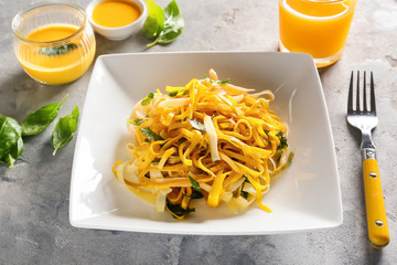 Plate of delicious pasta on table