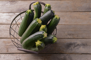 Basket with ripe zucchinis on wooden table