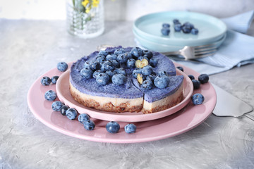 Obraz na płótnie Canvas Plate with tasty blueberry cheesecake on light table