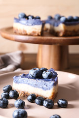 Piece of tasty cheesecake with blueberries on plate