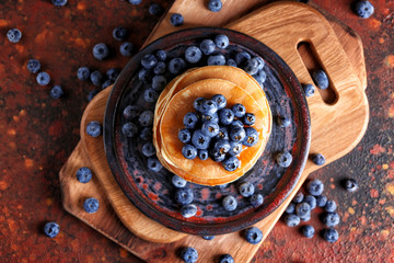 Plate with tasty pancakes and blueberries on table