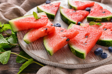 Wooden board with sweet watermelon slices on table, closeup