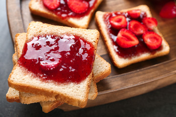 Slices of bread with delicious strawberry jam on board, closeup