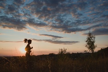 Young woman runner in sunset light. Nature, jogging, outdoor, freedom, success, happiness concept