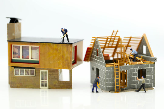 Miniature people : worker team for building home ,Image use for construction, business concept,house repair or home renovating