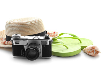 Stylish hat, camera and flip-flops on white background