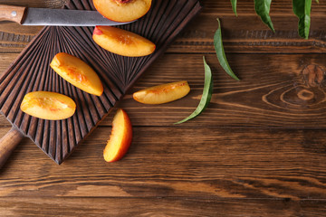 Board with fresh sliced peaches on wooden table
